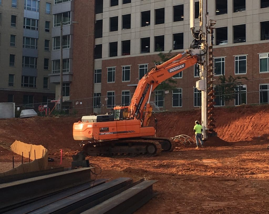 Photo showing drill rig predrilling prior to diving a solider pile